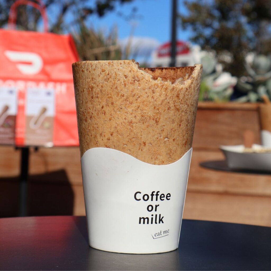 Bitten edible coffee cup with a protective sleeve, showcasing a sustainable zero-waste alternative to disposable cups
